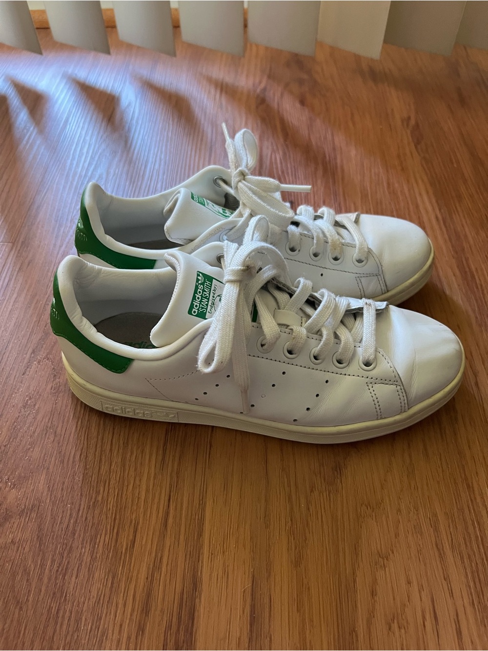 Adidas Stan Smith sneakers in the classic white and green colorway.